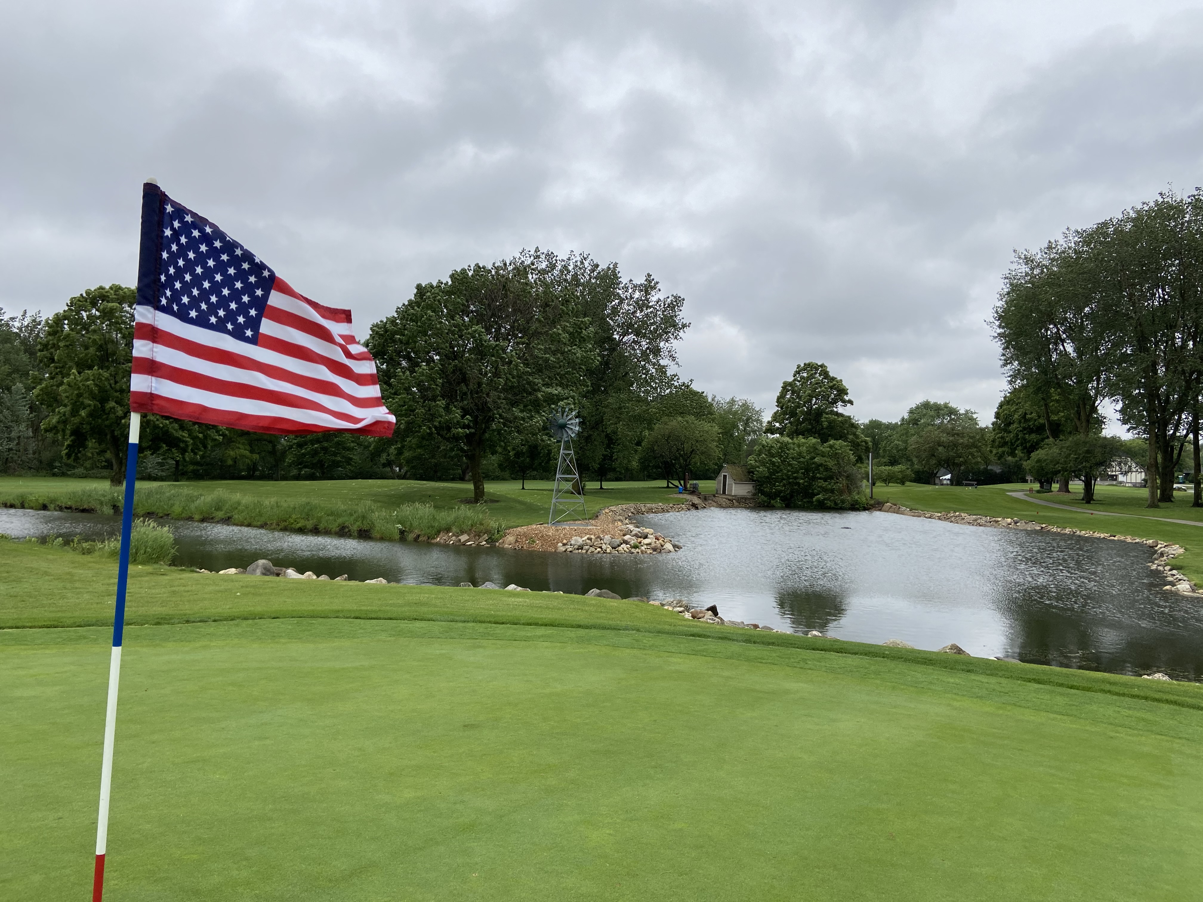 Cloudy golf course with an american flag
